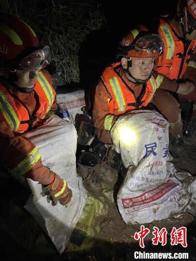 短暫修整期間，消防員脫掉鞋襪，用編織袋套住腿腳保暖。　閆旭輝 攝