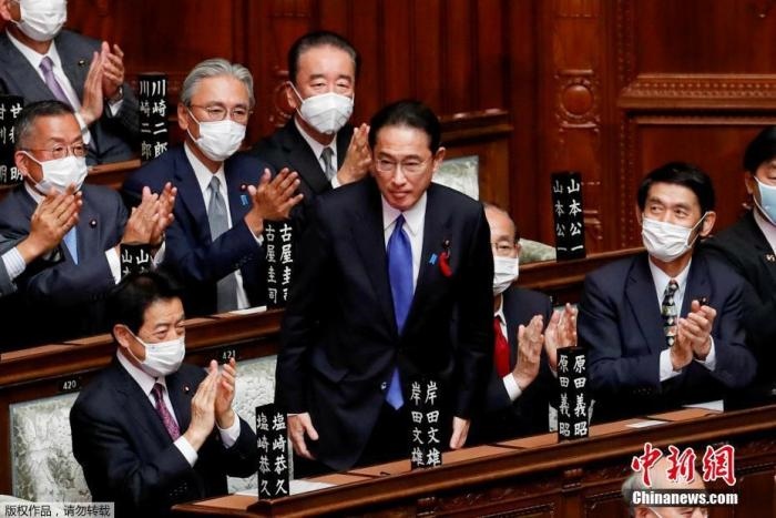 當?shù)貢r間10月4日，日本自民黨總裁岸田文雄經(jīng)過眾院全體會議的首相指名選舉成為第100任首相。圖為岸田文雄（中）起身致謝。