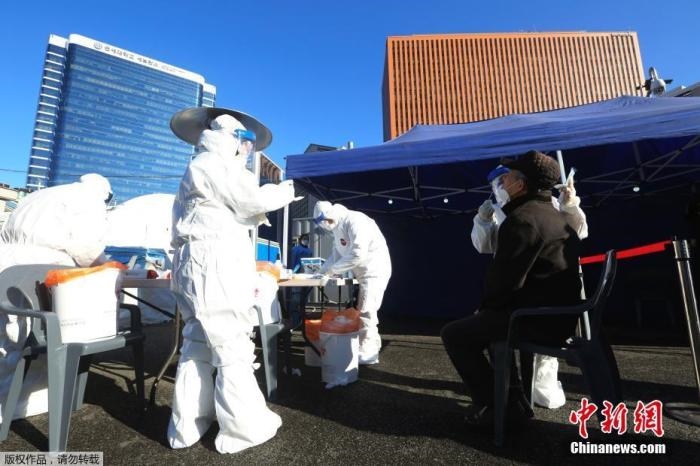 資料圖：韓國首爾，醫(yī)務(wù)人員對市民進行新冠病毒檢測。