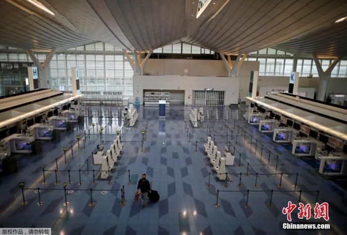 資料圖：日本東京，東京國(guó)際機(jī)場(chǎng)，一名乘客在國(guó)際航班航站樓的登機(jī)區(qū)。