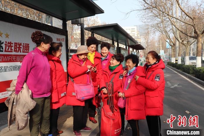 “防詐奶奶團(tuán)”在等公交車(chē)的間隙也不忘探討工作 李明芮 攝