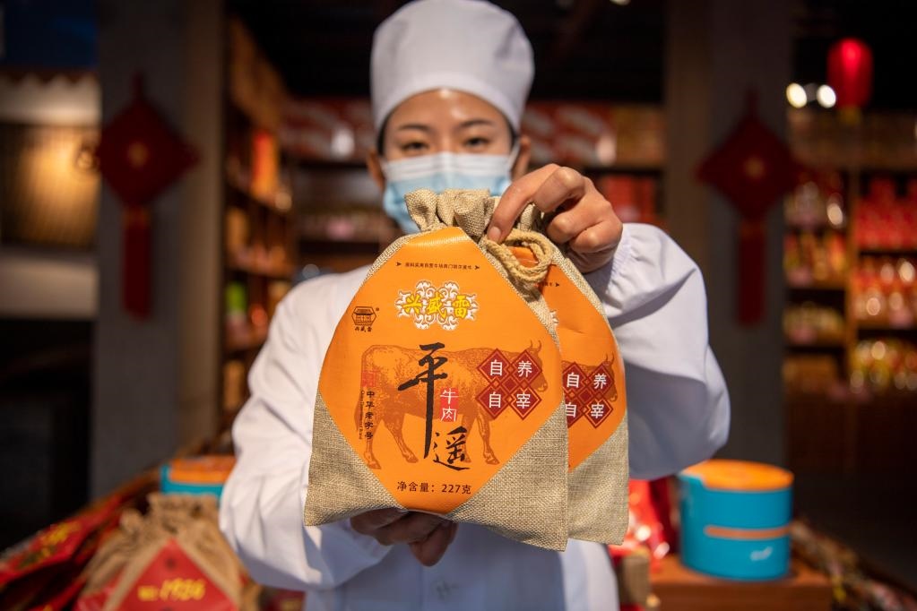 1月27日，在平遙古城南大街的一家平遙牛肉店內(nèi)，工作人員展示一款牛肉產(chǎn)品。新華社記者 楊晨光 攝