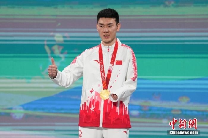 3月6日，梁景怡在延慶頒獎廣場領(lǐng)獎臺上豎起大拇指。當日，在國家高山滑雪中心舉行的北京2022年冬殘奧會殘奧高山滑雪男子超級大回轉(zhuǎn)—站姿決賽中，中國選手梁景怡奪得冠軍。 <a target='_blank' href='/'>中新社</a>記者 楊華峰 攝