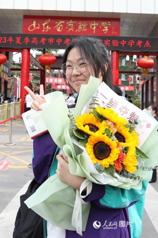 6月7日高考首日，山東67萬考生走進(jìn)考場(chǎng)，拼搏逐夢(mèng)。在山東省實(shí)驗(yàn)中學(xué)考點(diǎn)，考生進(jìn)考場(chǎng)前手捧向日葵花拍照留念，寓意“一舉奪魁”。人民網(wǎng)記者 劉祺攝