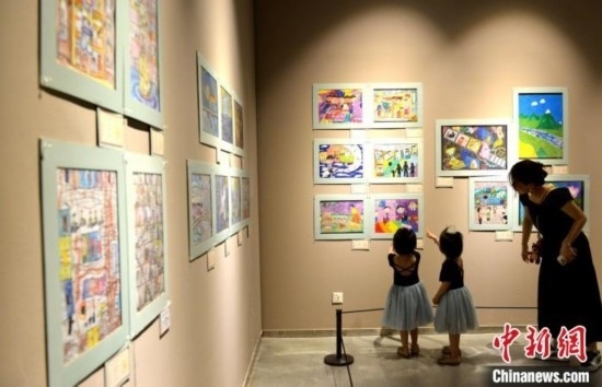 圖為家長帶著孩子參觀展覽。呂明 攝