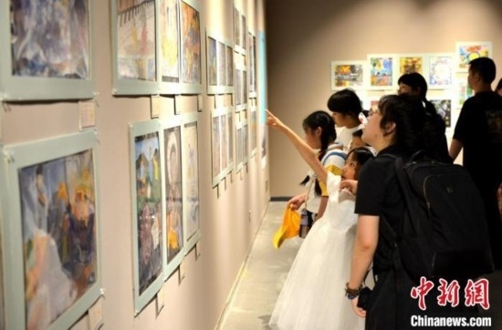 圖為家長帶著孩子參觀展覽。呂明 攝