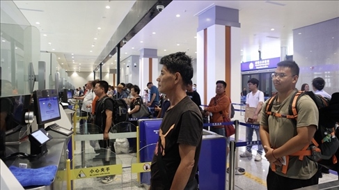 6月13日，乘坐中老鐵路國際旅客列車的旅客在磨憨邊檢大廳排隊候檢。李揚 攝