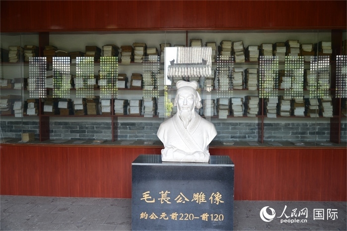 河間詩經(jīng)齋毛萇雕像。雕像后書櫥中陳列的是歷代各版本《詩經(jīng)》及譯本。 人民網(wǎng) 趙昭攝