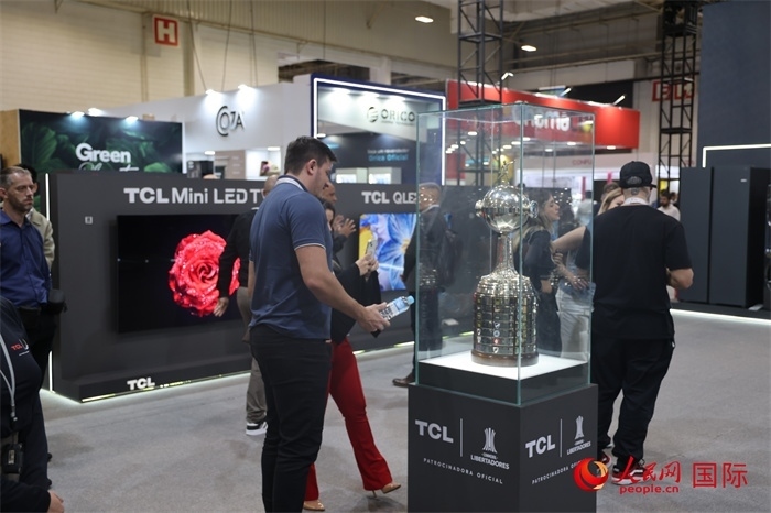 參觀者在TCL展臺(tái)前觀看南美解放者杯獎(jiǎng)杯，據(jù)介紹，TCL是南美解放者杯（2023—2026賽季）全球官方合作伙伴。（人民網(wǎng)記者 時(shí)元皓攝）