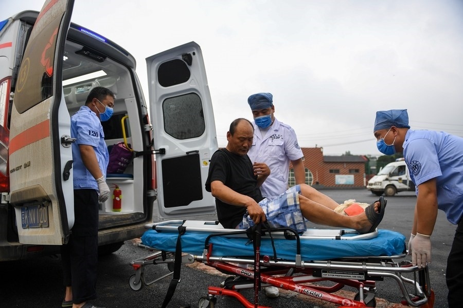 8月1日，在北京市門(mén)頭溝區(qū)妙峰山鎮(zhèn)妙峰山民族學(xué)校臨時(shí)安置點(diǎn)，北京急救中心工作人員在轉(zhuǎn)運(yùn)一名受傷村民。新華社記者 鞠煥宗 攝