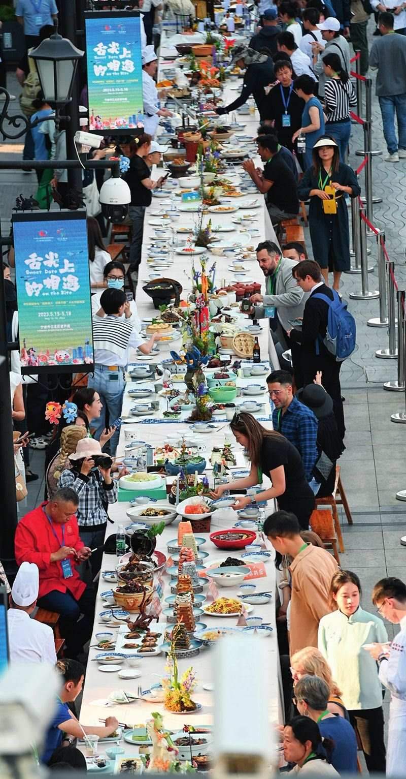 市民和游客在寧波舉辦的第三屆中國—中東歐國家博覽會暨國際消費(fèi)品博覽會上品嘗融合中國和中東歐美食的長桌宴（2023年5月15日攝）。黃宗治攝/本刊