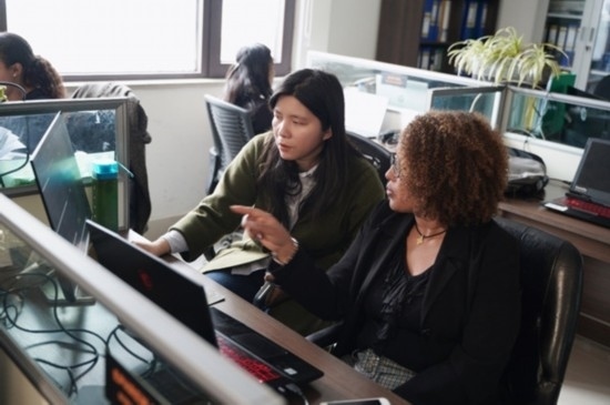 梅德哈妮（右）與中國同事討論設(shè)計方案。受訪對象供圖