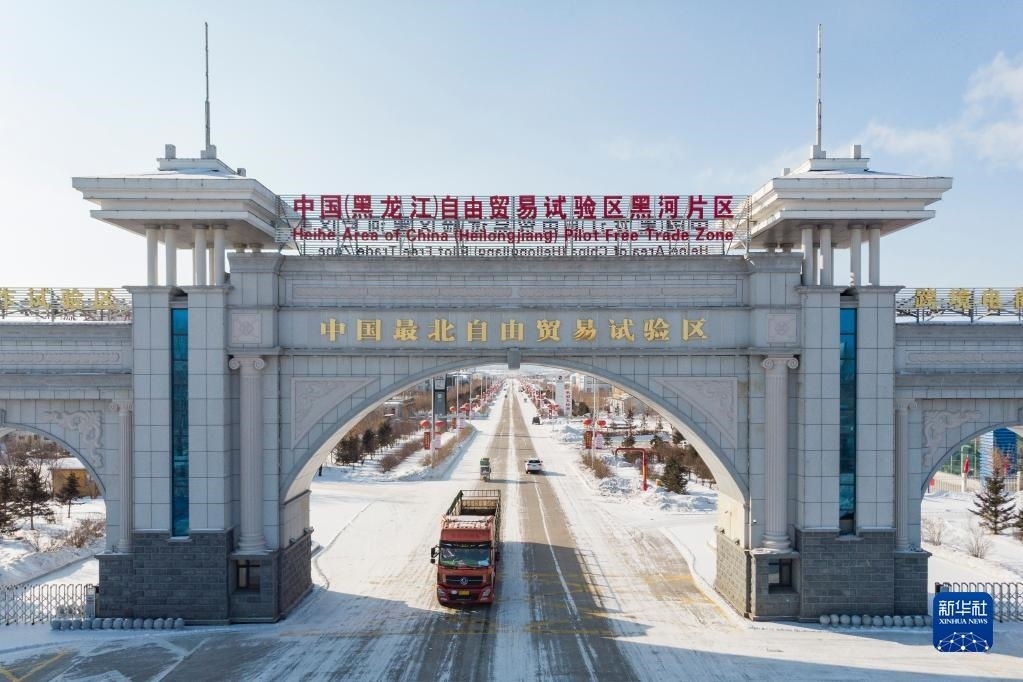 2月11日，車輛駛出中國(guó)（黑龍江）自由貿(mào)易試驗(yàn)區(qū)黑河片區(qū)大門（無(wú)人機(jī)照片）。新華社記者 謝劍飛 攝