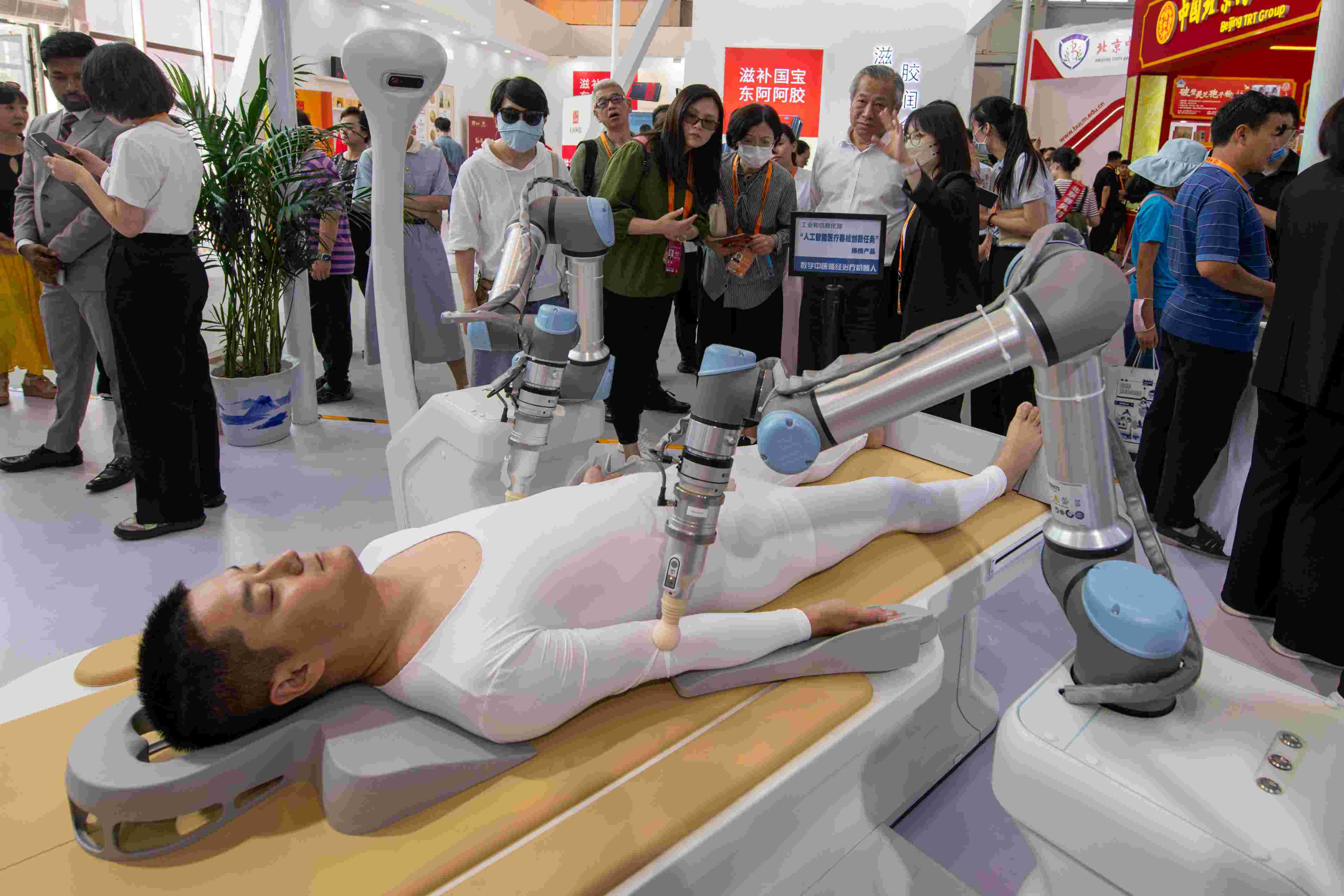 在位于首鋼園的健康衛(wèi)生服務(wù)展區(qū)，觀眾正在參觀數(shù)字中醫(yī)循經(jīng)治療機(jī)器人。人民網(wǎng)記者 翁奇羽攝
