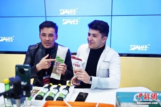 2023年3月，甘肅省慶陽市環(huán)縣電商創(chuàng)業(yè)孵化基地內(nèi)，來自蘭州文理學(xué)院的塔吉克斯坦留學(xué)生正在協(xié)助主播直播帶貨當(dāng)?shù)剞r(nóng)特產(chǎn)品。李亞龍 攝