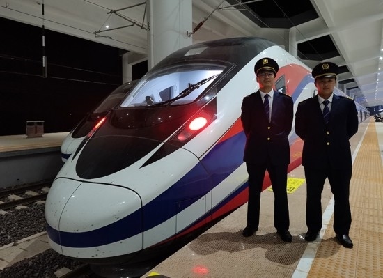 劉銀能（右一）與中國師父鄔俊鴻在動車組前合影。受訪者供圖