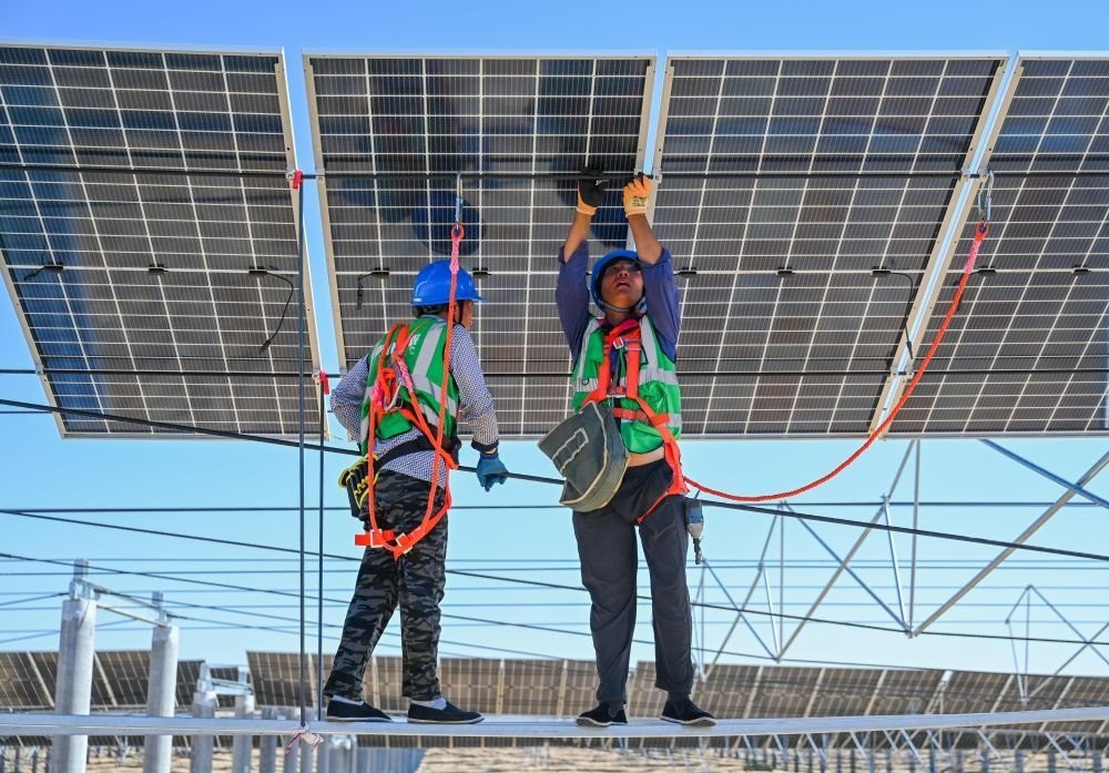 2023年7月22日，工人在位于內蒙古杭錦旗庫布其沙漠億利生態(tài)示范區(qū)的蒙西基地庫布其200萬千瓦光伏治沙項目工地安裝光伏板。新華社記者 劉磊 攝