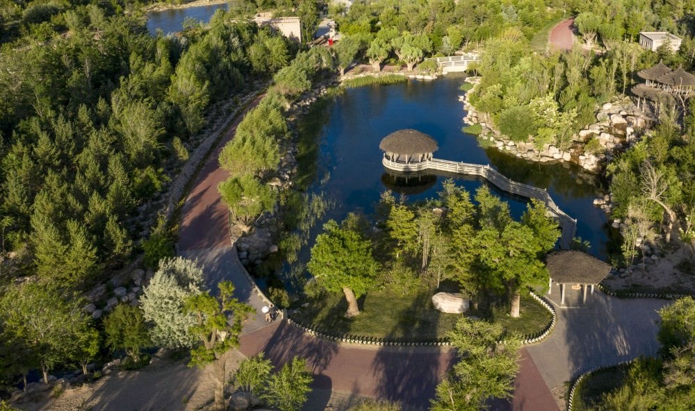 坐落在寧夏銀川市賀蘭山腳下的賀蘭山運動休閑公園（2021年5月27日攝，無人機照片）。這里曾是一片砂石采礦塌陷區(qū)，當地通過植被景觀再造、水系建設、現代管網鋪建等手段，重新利用廢石、廢坑及各類廢棄建筑材料，把這里變成一座免費開放的主題公園。新華社記者 馮開華 攝