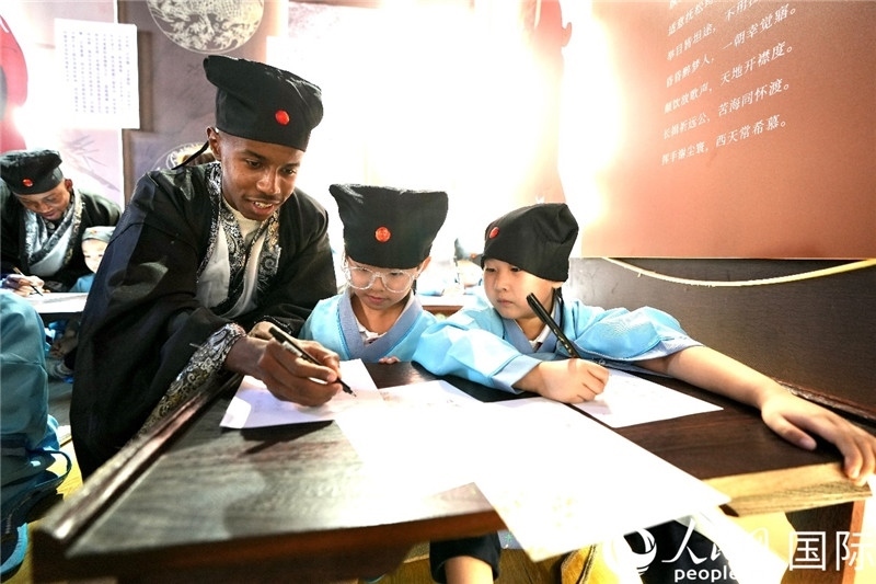 圖為選手與同學(xué)們一起寫書法。人民網(wǎng) 盧鵬宇攝