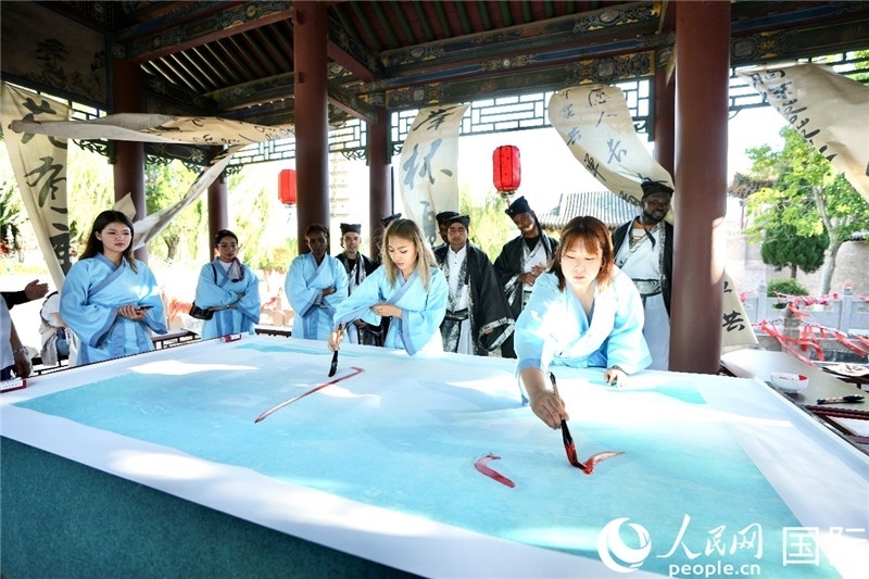 選手們提筆書寫“家園”二字。人民網(wǎng) 盧鵬宇攝