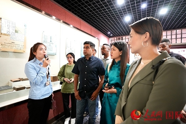 選手們認(rèn)真聆聽導(dǎo)游講解。人民網(wǎng) 盧鵬宇攝