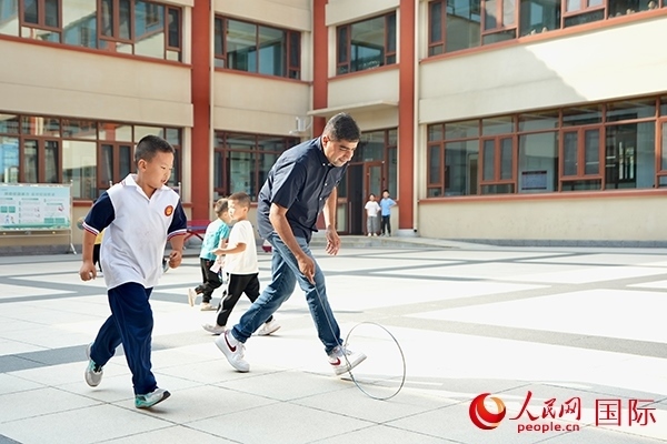 來(lái)自巴基斯坦的沙杰在滾鐵環(huán)。人民網(wǎng) 盧鵬宇攝