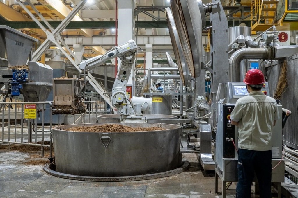 907車(chē)間里，機(jī)械臂正在撒料裝甑。嚴(yán)磊攝