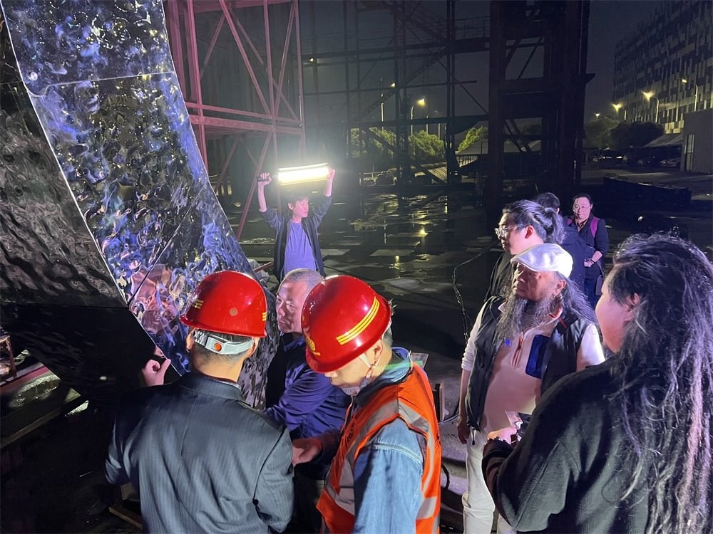 林崗（右二）和團(tuán)隊(duì)查看主火炬制作進(jìn)度。受訪(fǎng)者供圖