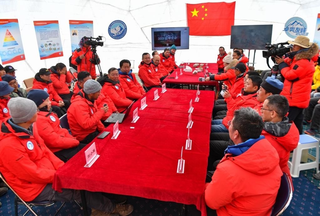 海拔4950米的卓奧友峰科考大本營，科考隊(duì)員趙華標(biāo)（手拿麥克風(fēng)看電腦者）在宣讀剛剛接收到的頂峰氣象觀測數(shù)據(jù)，這標(biāo)志著峰頂自動氣象站架設(shè)成功，成功傳回觀測數(shù)據(jù)（10月1日攝）。新華社記者晉美多吉 攝