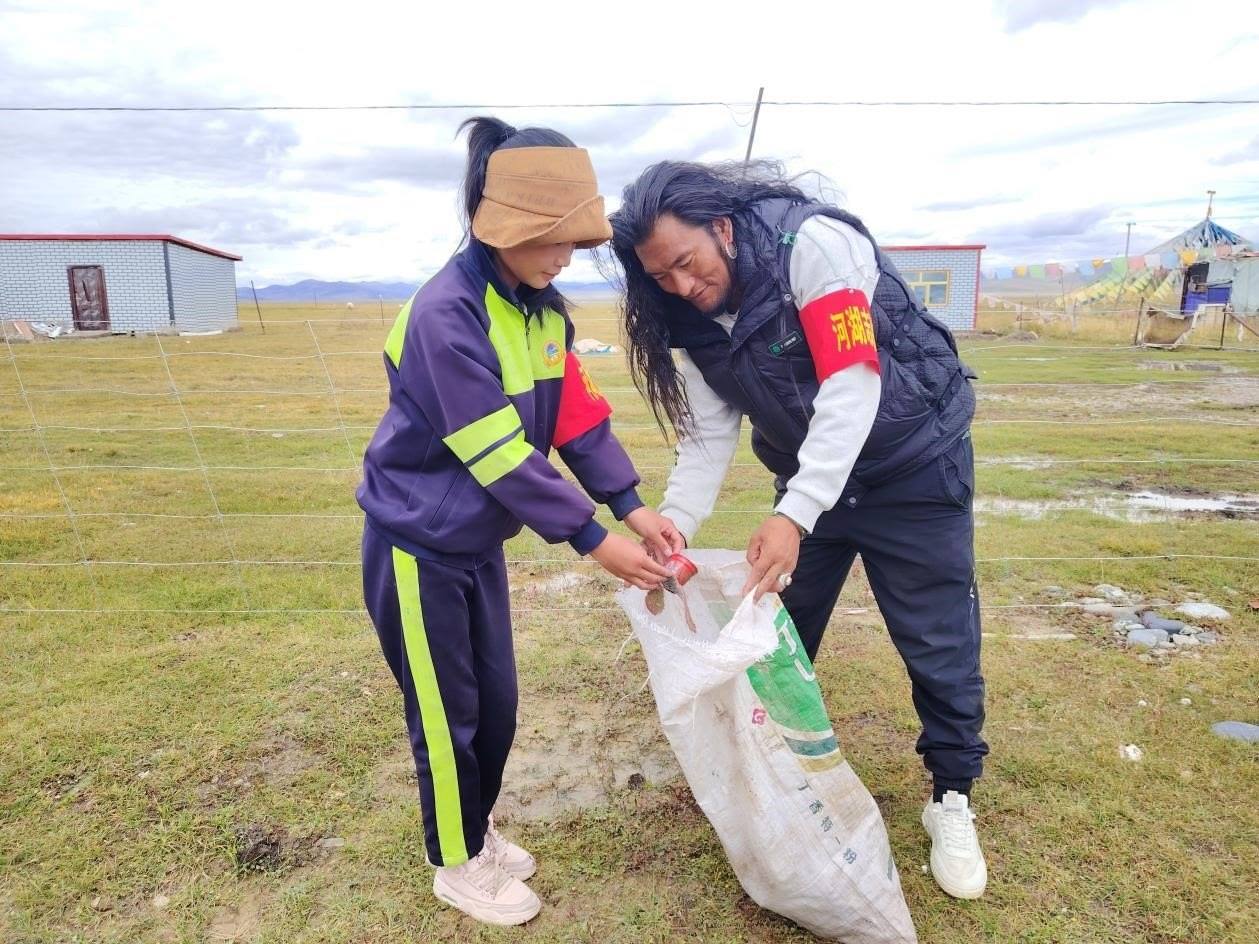 玉樹州稱多縣珍秦鎮(zhèn)河湖志愿者才培和他女兒更求拉毛在清掃垃圾。受訪者供圖