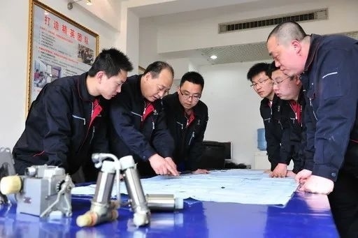 △李志強(qiáng)（左二）與班組成員在研究工作。