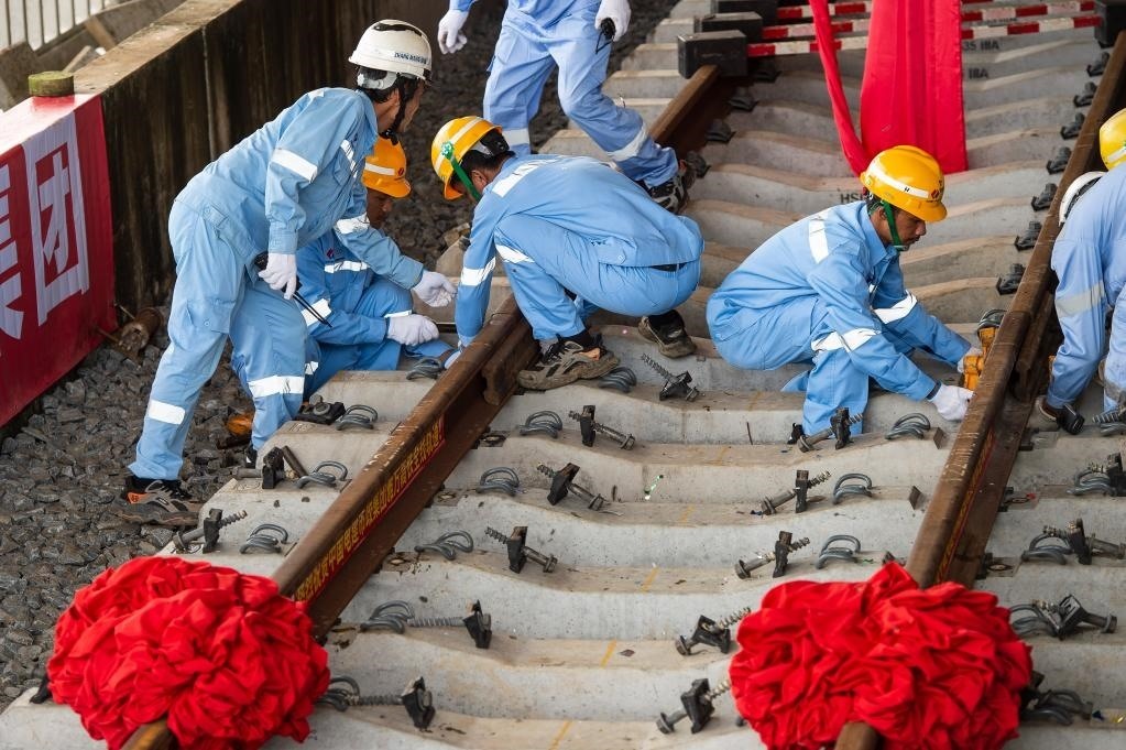 3月31日，在印度尼西亞雅加達(dá)雅萬高鐵哈利姆車站，工人鋪設(shè)雅萬高鐵全線最后一根鋼軌。