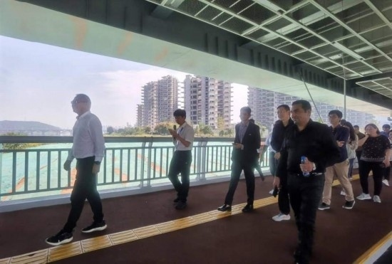 10月24日，2023“一帶一路”媒體合作論壇聯(lián)合采訪團團員走在清水塘大橋景觀通道上。本報記者 常雯宜攝