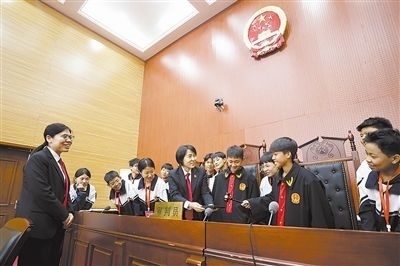 圖③：同學們穿法袍、敲法槌，爭做“小法官”。