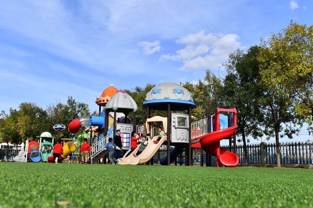 在山東省東營市墾利區(qū)楊廟社區(qū)幼兒園，孩子們在老師的帶領(lǐng)下進(jìn)行戶外活動(dòng)（2021年10月19日攝）。新華社記者 郭緒雷 攝