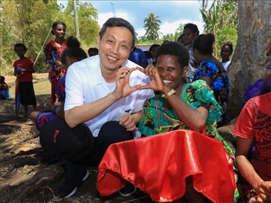 2023年12月18日，中國(guó)駐瓦努阿圖大使李名剛和前來觀看瓦努阿圖公路項(xiàng)目二期馬勒庫(kù)拉段移交儀式的當(dāng)?shù)鼐用窈嫌?。人民網(wǎng) 賀吉攝