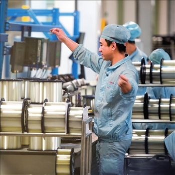 在位于武漢的長飛光纖光纜股份有限公司光纖生產(chǎn)車間內(nèi)，工作人員對光纖進行檢測（資料圖片）。肖藝九攝/本刊