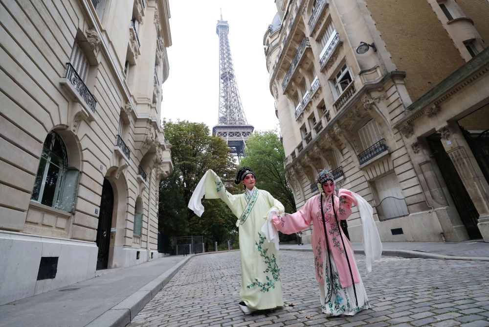 2023年9月13日，江蘇省演藝集團(tuán)昆劇院院長(zhǎng)施夏明（左）和江蘇省演藝集團(tuán)昆劇院國(guó)家一級(jí)演員孔愛(ài)萍在法國(guó)巴黎埃菲爾鐵塔附近參加昆曲快閃。新華社記者 高靜 攝