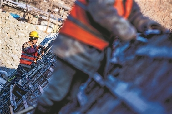 1月3日，房山區(qū)，工人正在雙泉河修筑堤壩。