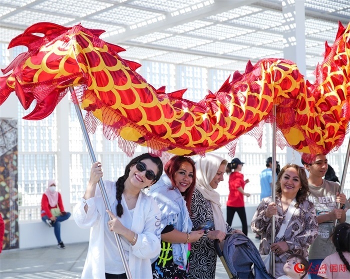 游客體驗(yàn)舞龍。 人民網(wǎng) 塔里克·易卜拉欣攝