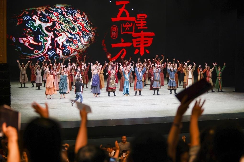 2023年7月31日，新疆和田地區(qū)新玉歌舞團在烏魯木齊京劇院演出舞劇《五星出東方》后和觀眾互相揮手致意。這場演出是第六屆中國新疆國際民族舞蹈節(jié)的參演劇目之一，曾榮獲國家“文華獎”等。新華社記者 郝昭 攝