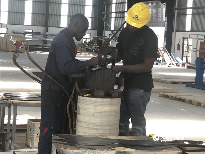 經(jīng)貿(mào)合作區(qū)廠房內(nèi)，當(dāng)?shù)毓と苏诰o張作業(yè)。人民網(wǎng)記者 黃培昭攝