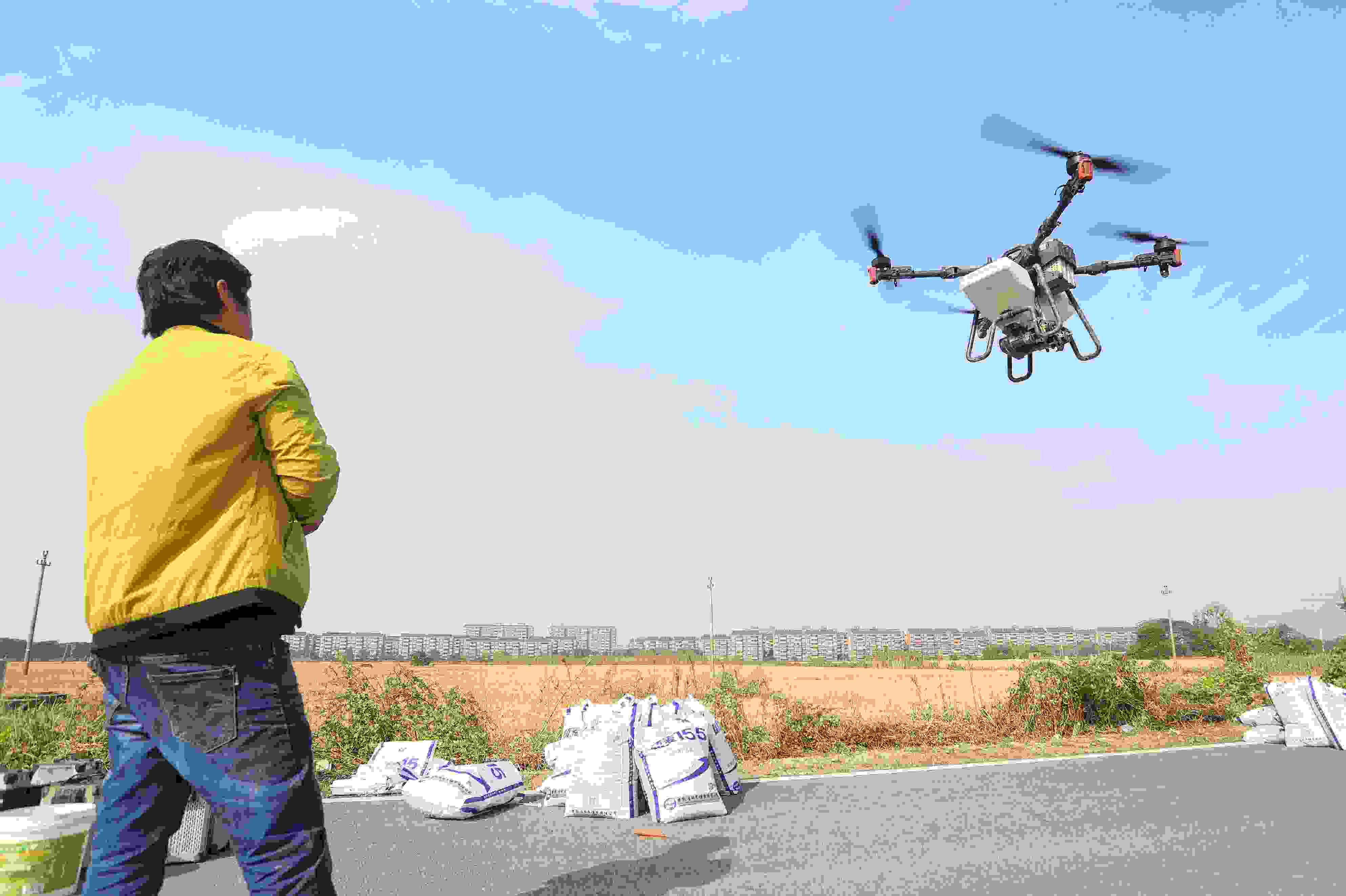 2023年11月15日，浙江嘉興，南湖區(qū)七星街道一處農(nóng)田里，農(nóng)民操縱無人機進行冬小麥飛播。