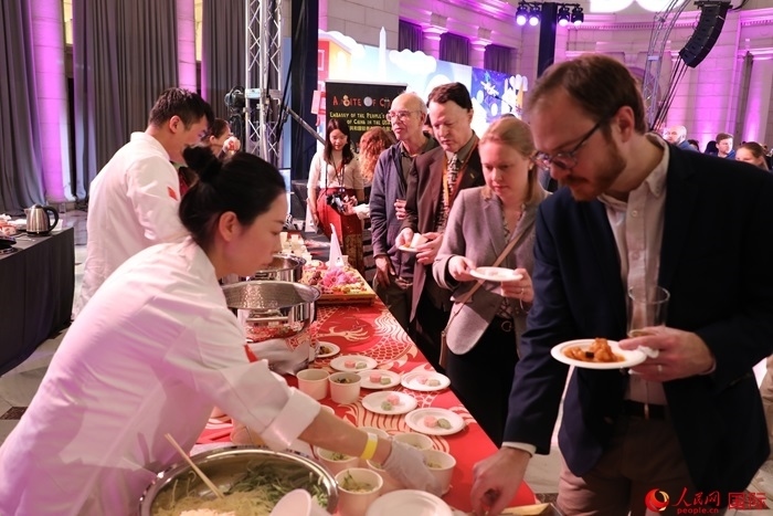 當(dāng)?shù)貢r(shí)間3月7日晚，華盛頓聯(lián)合車(chē)站廣場(chǎng)舉行駐美使團(tuán)“使館主廚挑戰(zhàn)賽”。圖為當(dāng)?shù)孛癖娫谥袊?guó)展臺(tái)前體驗(yàn)中國(guó)美食。人民網(wǎng)記者 李志偉攝