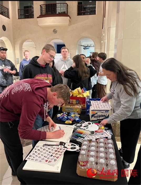 學(xué)生們出發(fā)前紛紛在留言簿留言。人民網(wǎng)記者 鄧圩攝