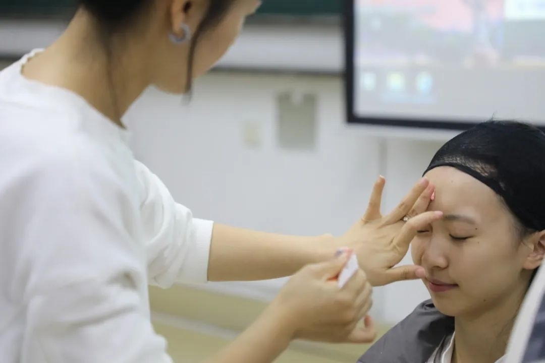 課堂上，一名學(xué)生在體驗(yàn)上戲妝。學(xué)校供圖