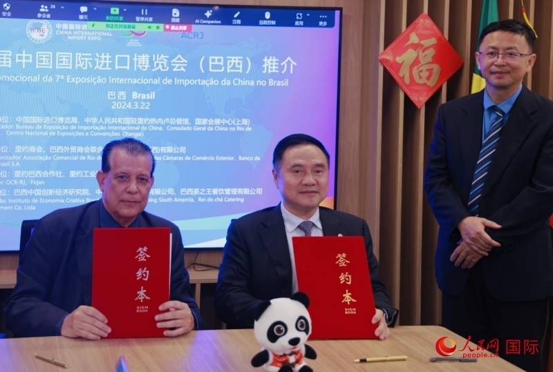 巴西外貿(mào)商會聯(lián)合會會長阿代爾·羅伯托（左）與中國國際進口博覽局副局長吳政平（中）現(xiàn)場簽訂協(xié)議。人民網(wǎng)記者 宋亦然攝