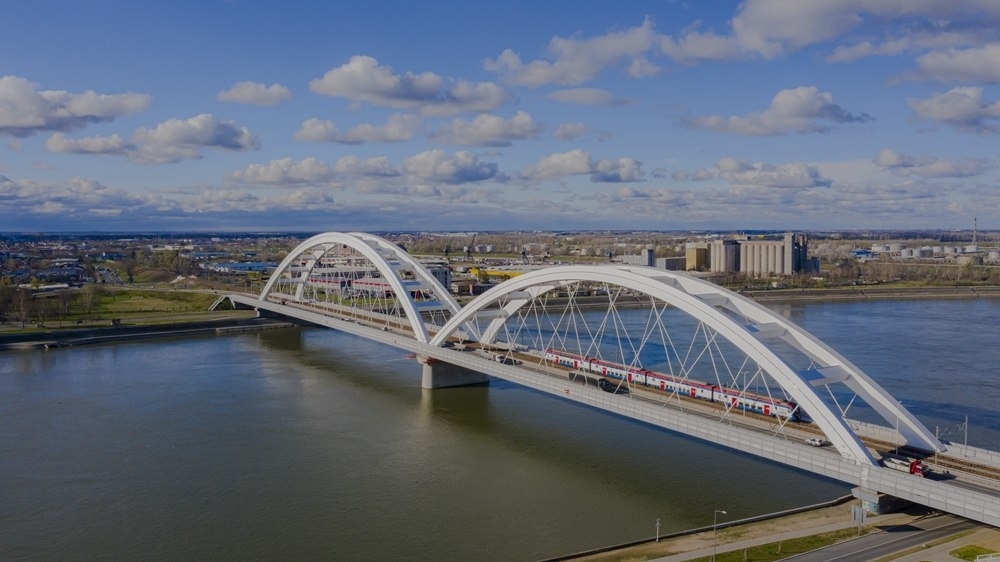 2024年3月12日，一列火車運(yùn)行在匈塞鐵路塞爾維亞境內(nèi)貝諾段諾維薩德多瑙河大橋上（無人機(jī)照片）。新華社發(fā)（任衛(wèi)云攝）