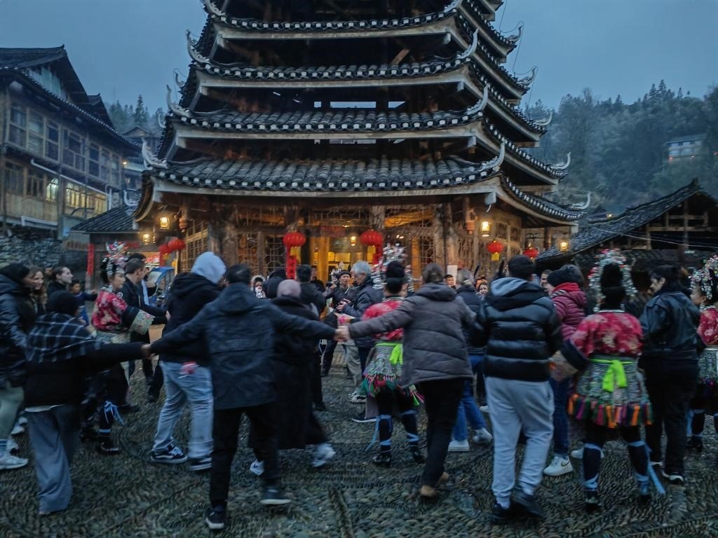 法國青年與當?shù)卮迕駹渴痔?。新華社記者 羅羽 攝