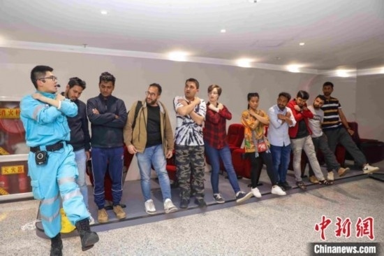 5月9日，工作人員指導留學生練習逃生技巧。張鷹 攝